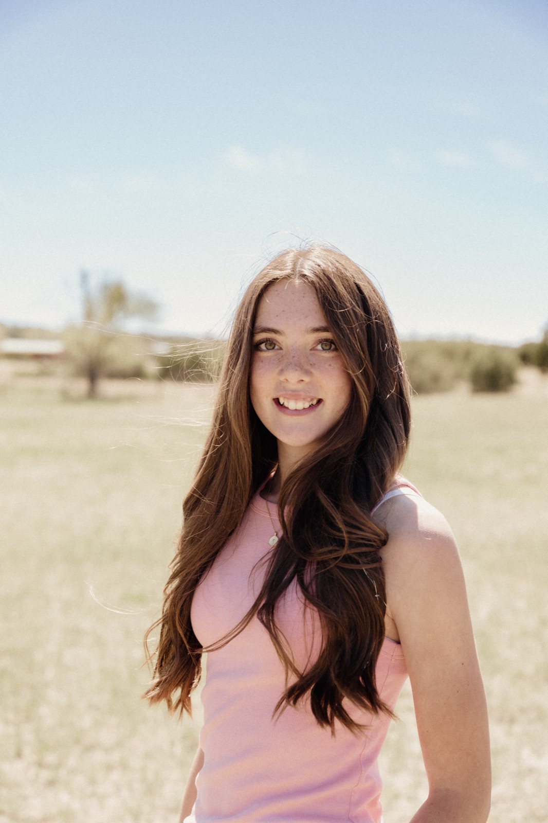 Sailor smiling in a sunny field, her long hair catching the breeze